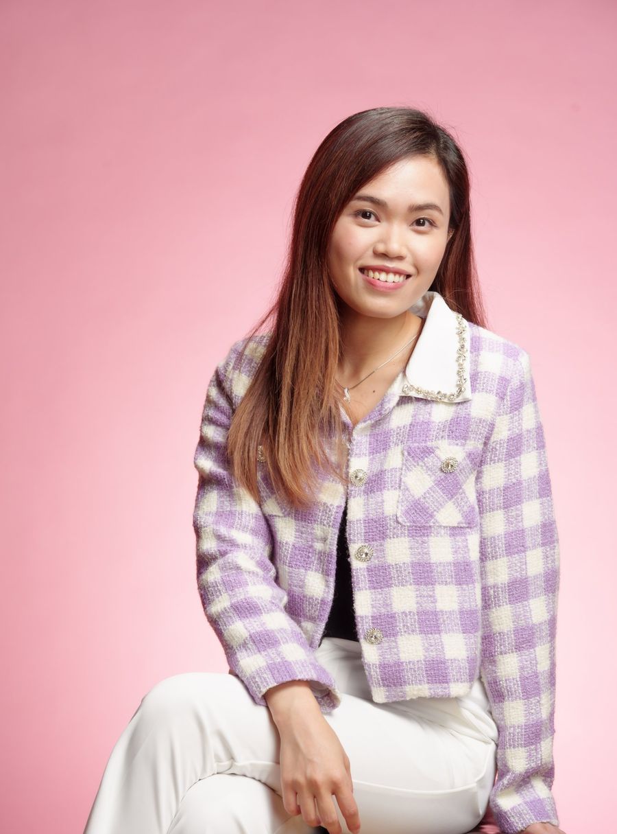 Portrait of Agnes in a lilac jacket against a pink background